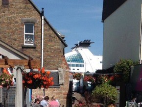 The exterior of a cafe with flowers, seats and the sky