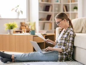 A woman looking at an energy bills and her laptop