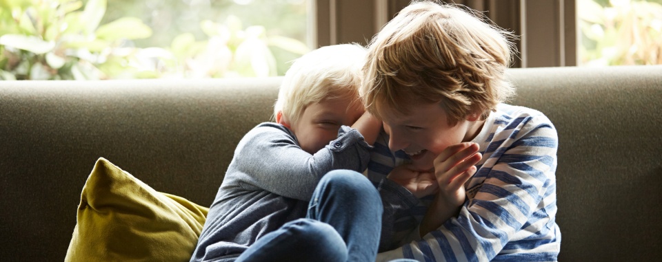 2 children playing on a couch in their home