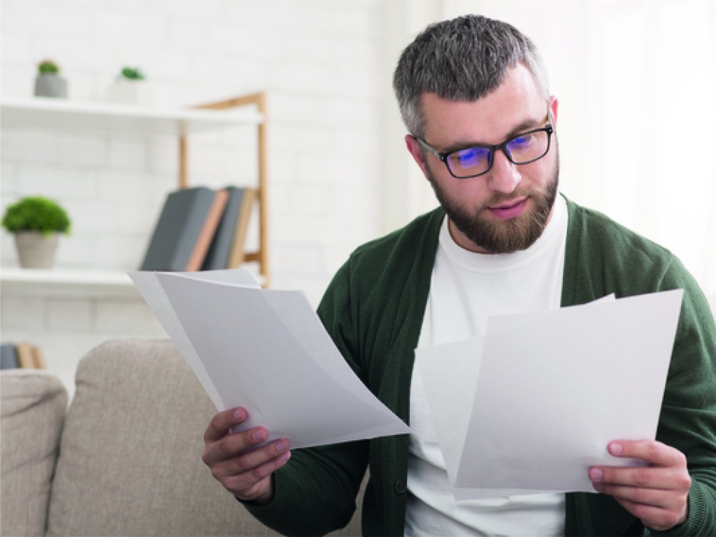 a man inspecting his energy bills