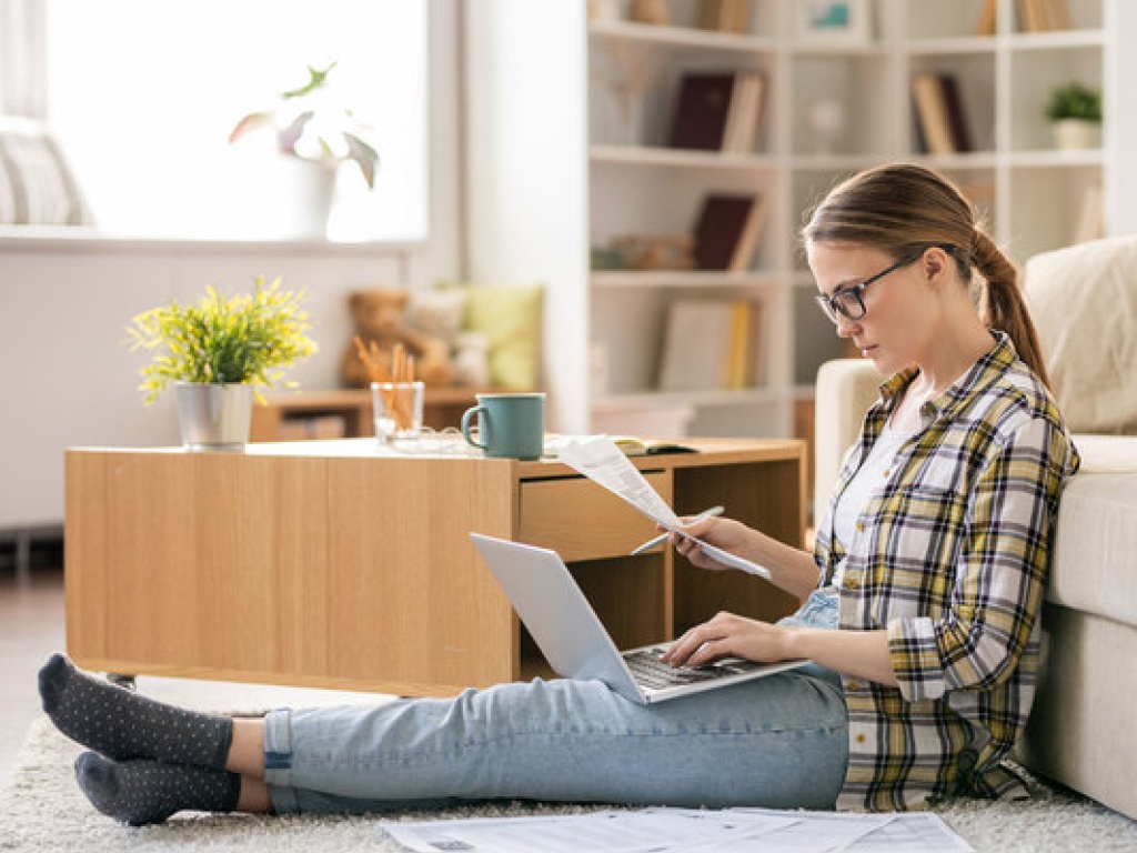 A woman looking at an energy bills and her laptop