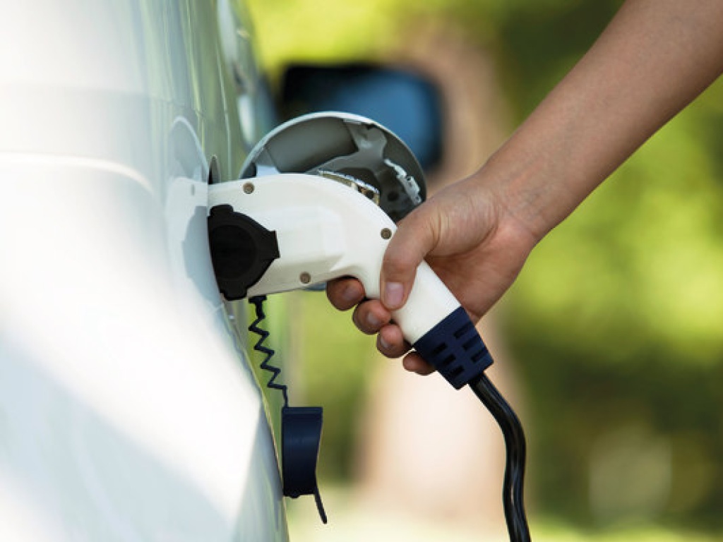 a person charging an electric vehicle