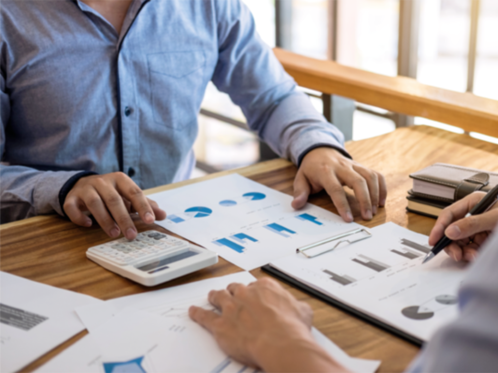 2 people inspecting pages of graphs and charts